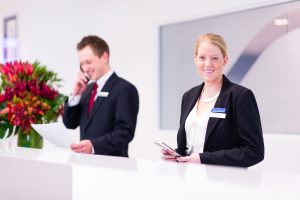 Two people working in front desk