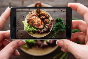 A girl taking picture of her food from bird's eye view