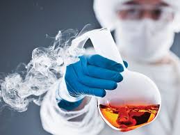 A scientists holding up a chemical.