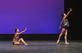 Two dances on stage doing modern dance.