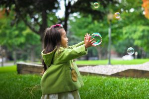 Toddler grabbing bubbles while playing