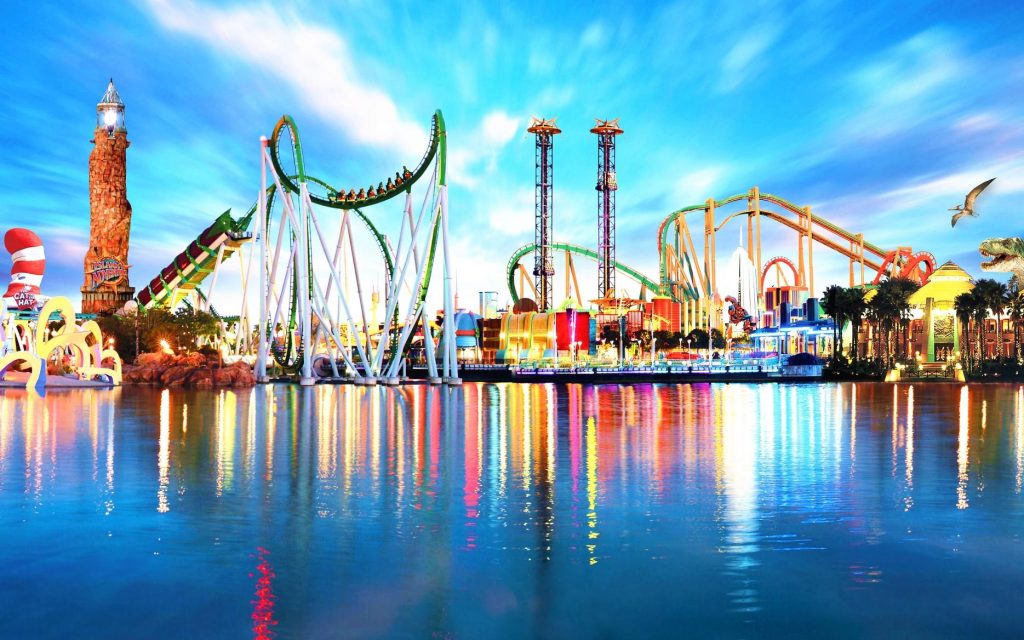 view of an amusement park from the water showing rides and other attractions.