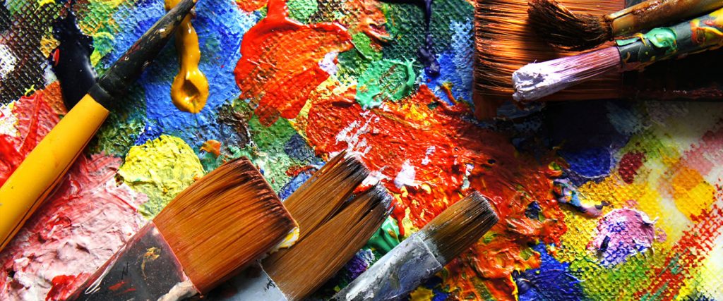 Paint brushes laying on a canvas.