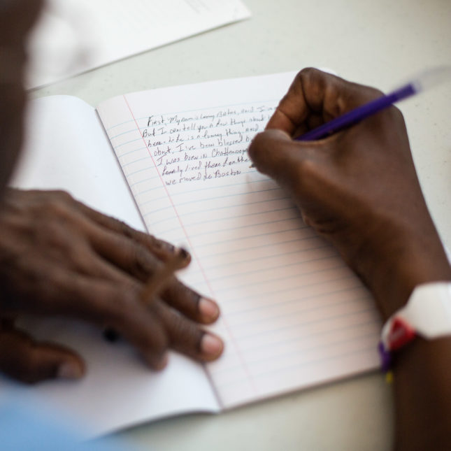 A man writing in a journal.