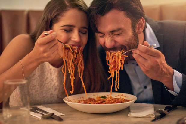 Man and woman sharing a plate of spaghetti