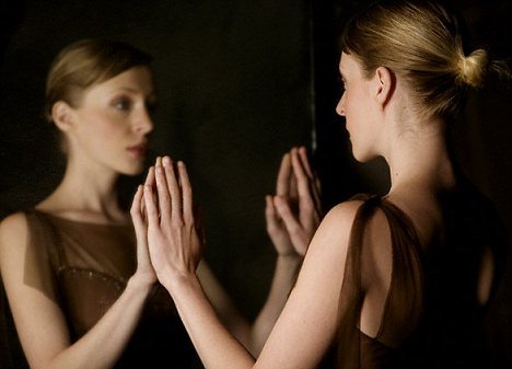 Woman looking at her own reflection