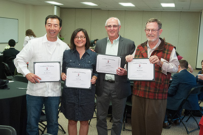 This image shows Professor Semm with his colleagues as they display various certificates.