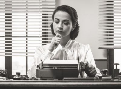 Female playwright writing with a vintage typewriter