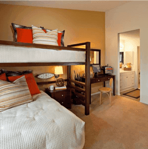 Bunk bed next to desk and bathroom