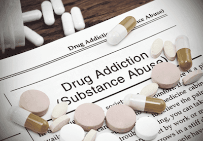 Drug and pills on an article about drug addiction