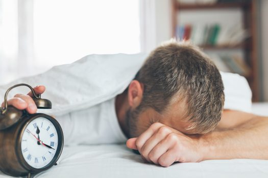 Young man finding it difficult to wake up in the morning