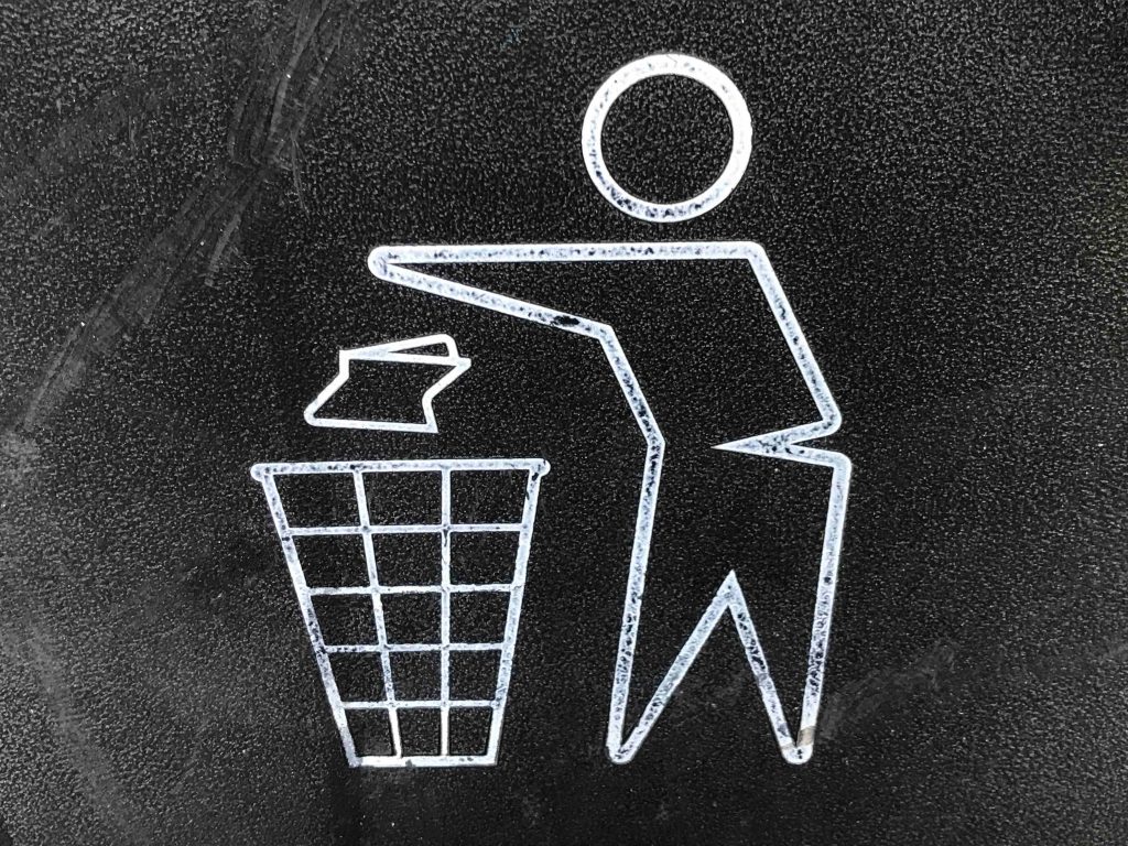 outlined image of person throwing out trash in the garbage bin.