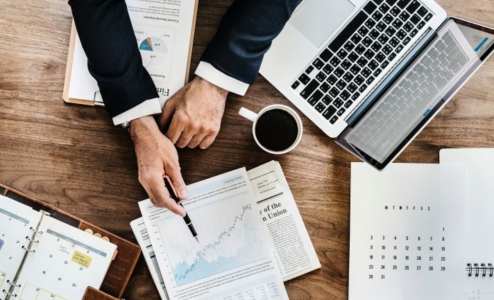 man in suit working on financial reports and looking at economic trends at job