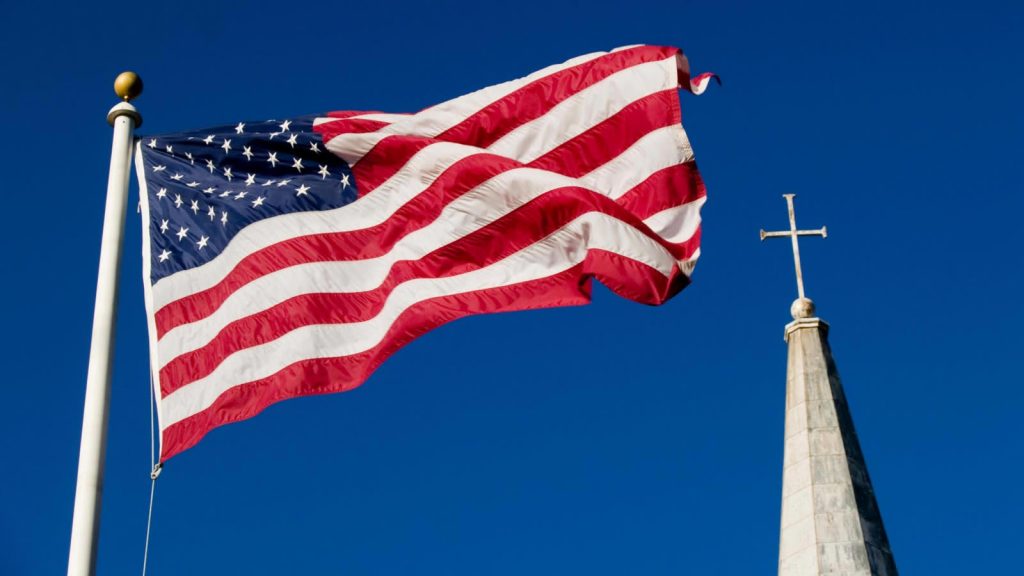 An American flag beside a Church's cross