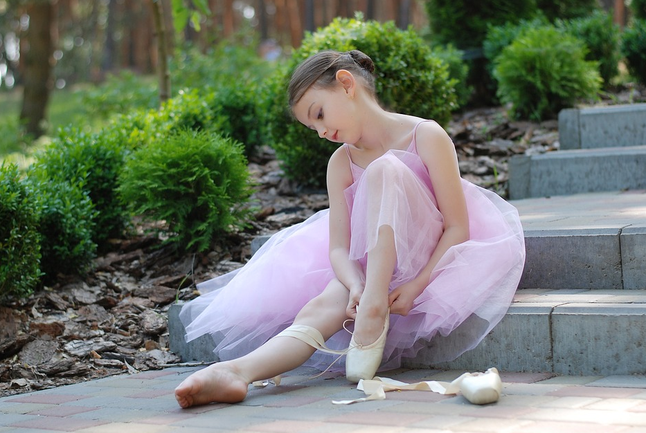Dancer wearing a beautiful dress while fixing her shoes