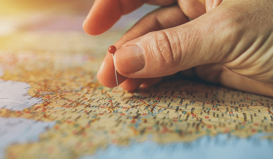 hand putting a pin on a map