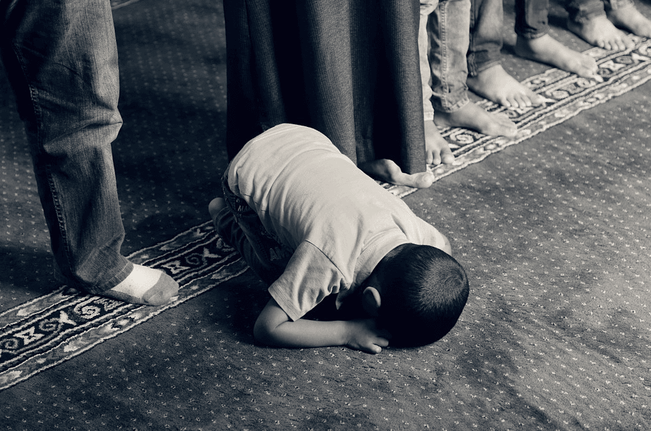 child praying on a mat, bowing down