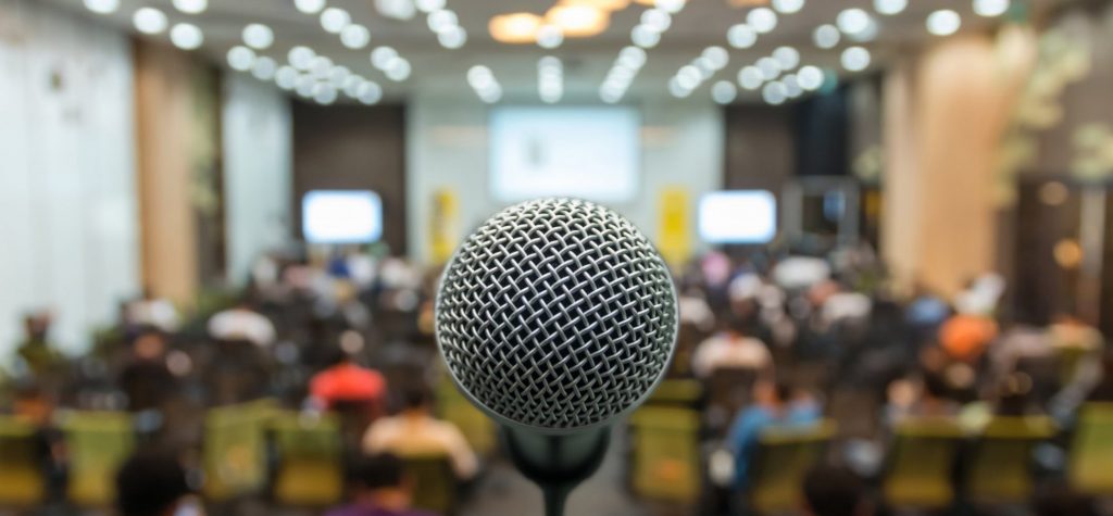 A microphone on a stage in front of an audience