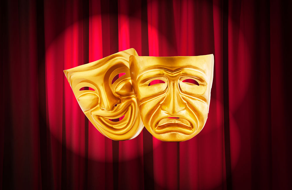 Acting masks in front of a theatre's curtains