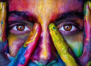 A person's face painted with different colors