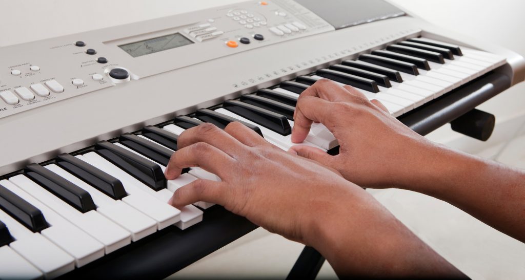 A persons hands playing the keyboard