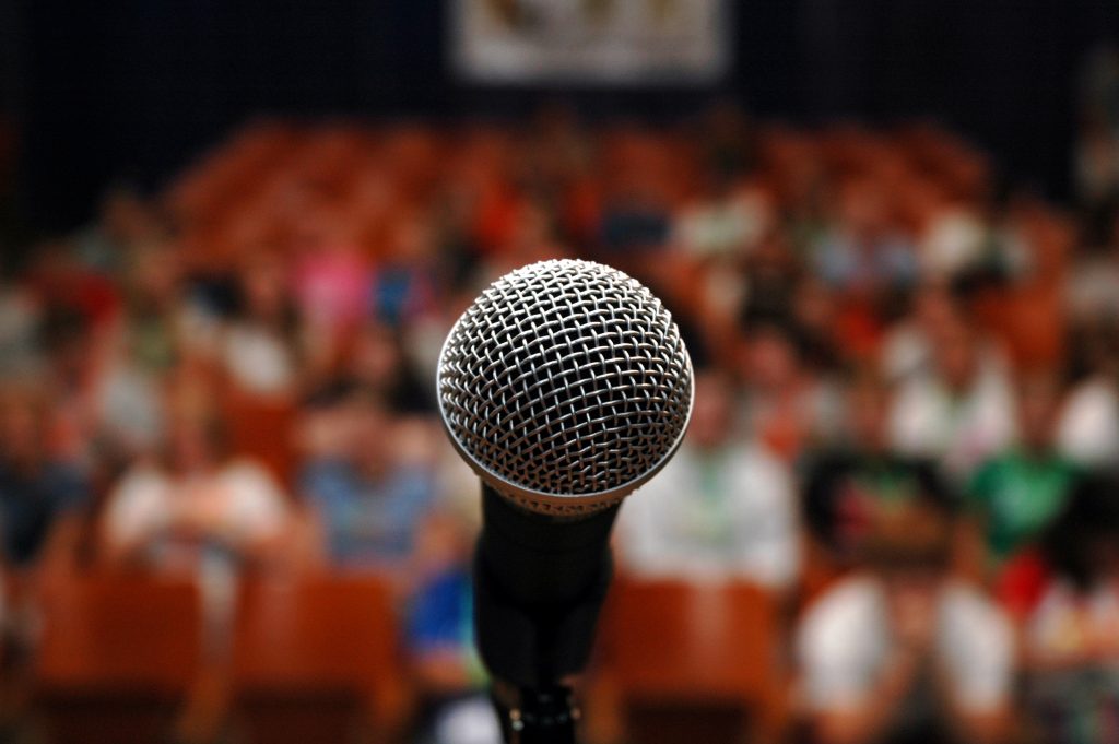 A microphone on a stage in front of an audience