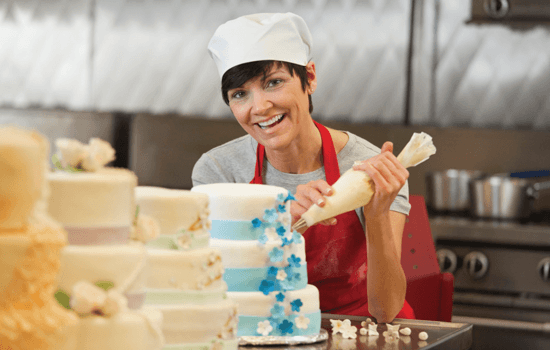A pastry chef decorating a cake