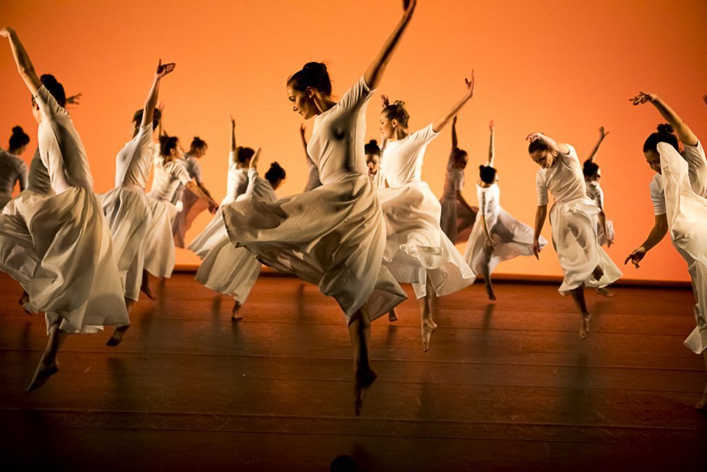 Female dancers performing a dance in white garments