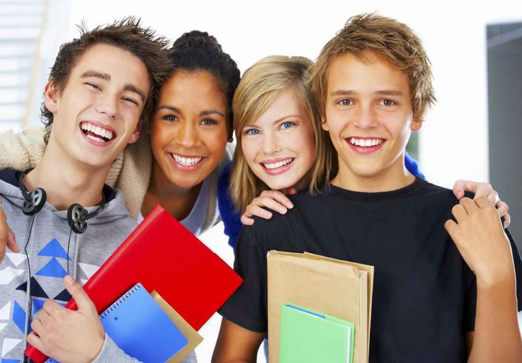 Four teenagers posing for a picture