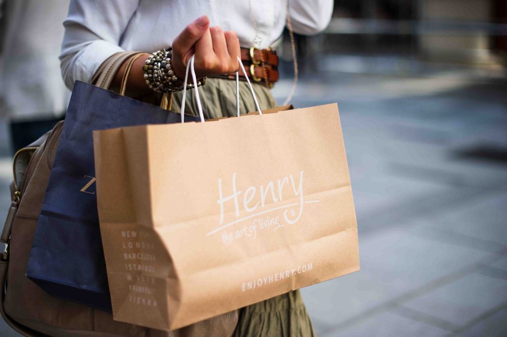 stylish lady holding shopping bags of clothes and apparel