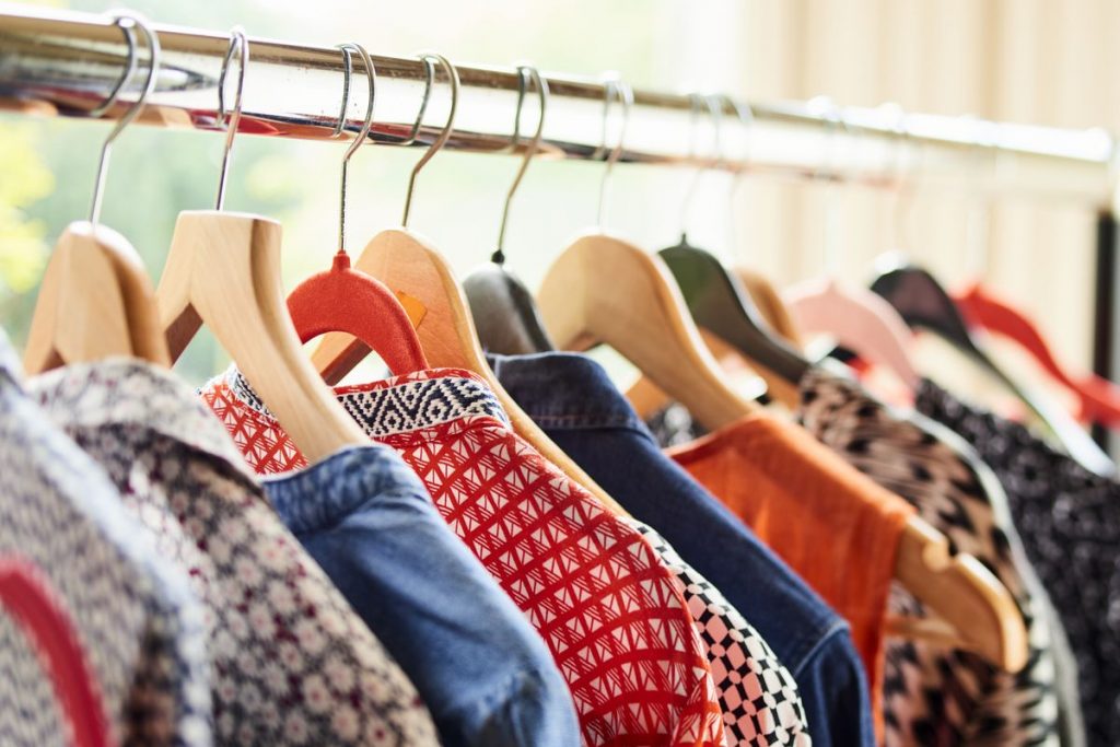 shirts and other clothing for students hanging on a rack