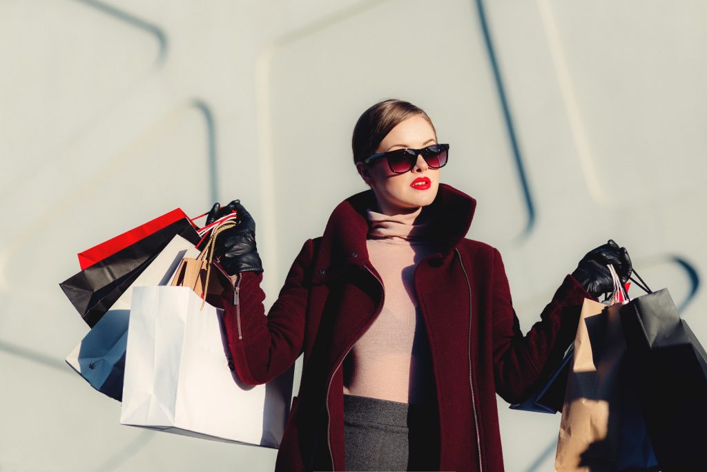 female student going shopping and holding shopping bags of clothing and apparel from a mall