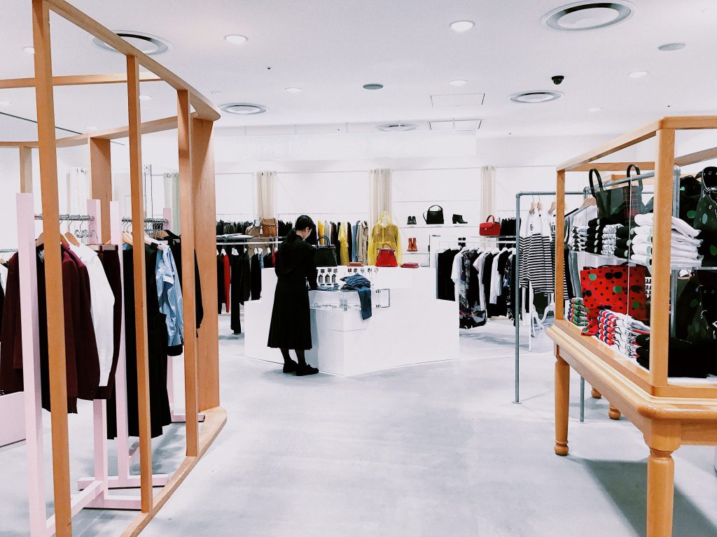 male student in retail store shopping for clothes
