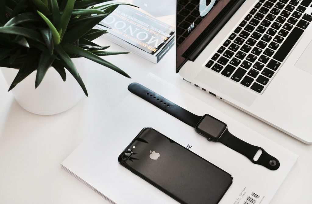 laptop, tablet, phone and other technology products laying on table