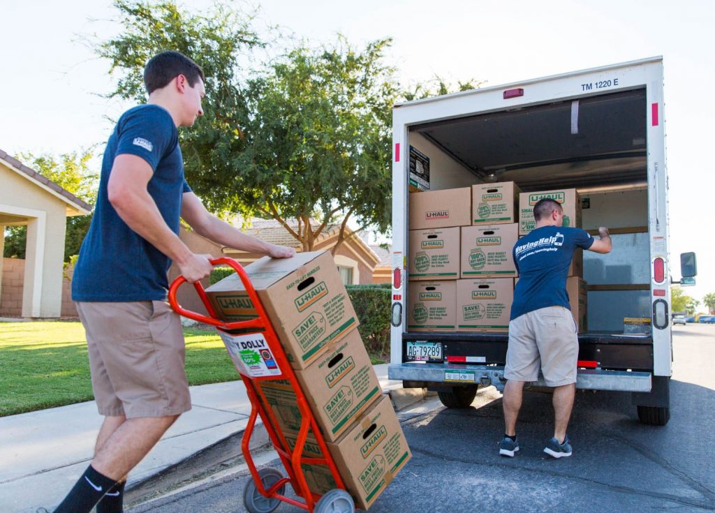movers moving someone using uhaul boxes and trucks.