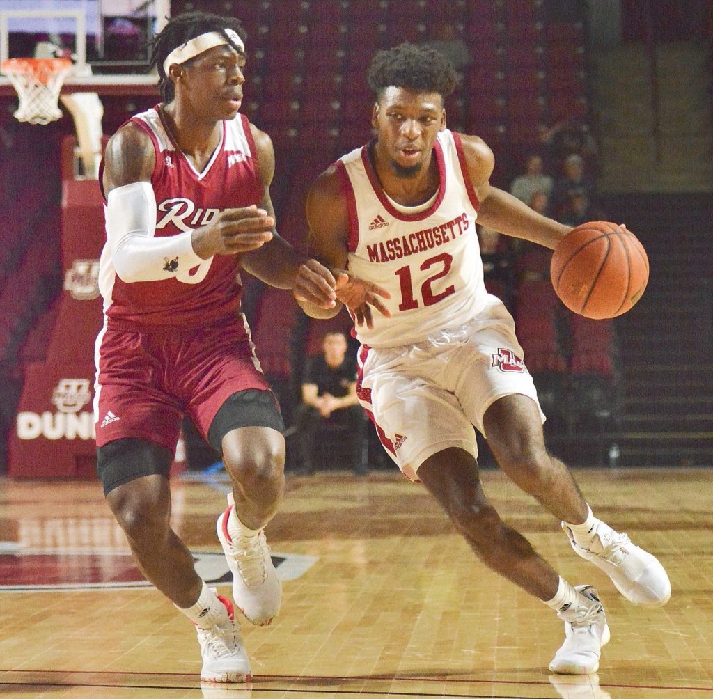 An UMass male basketball player dribbling past an opponent
