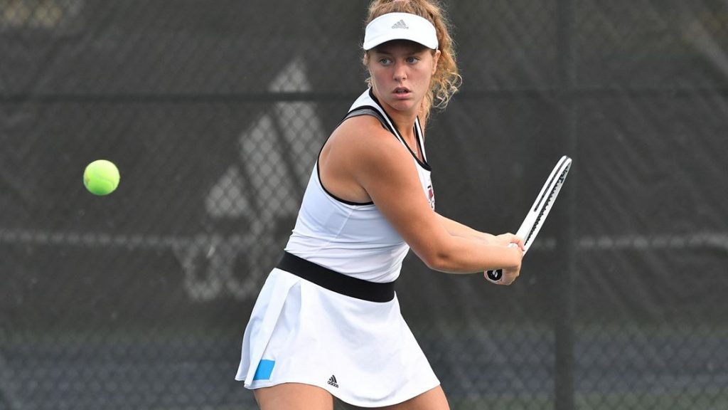 A female tennis player positioned to receive the ball