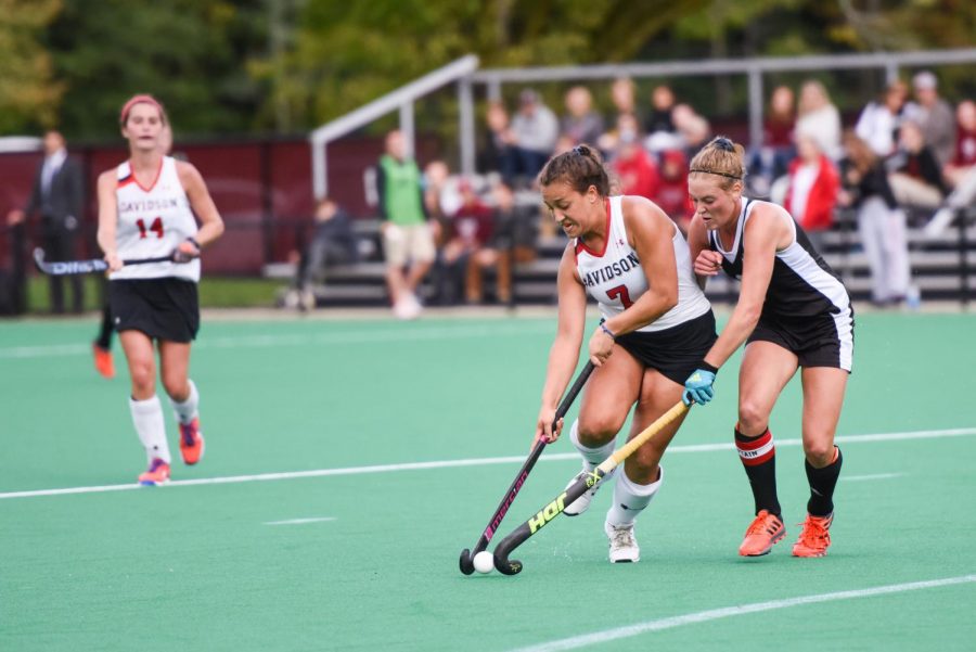 Female field hockey players contesting on the pitch