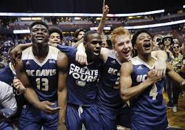 basketball players huddled together smiling and cheering