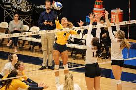 players grabbing for the volleyball