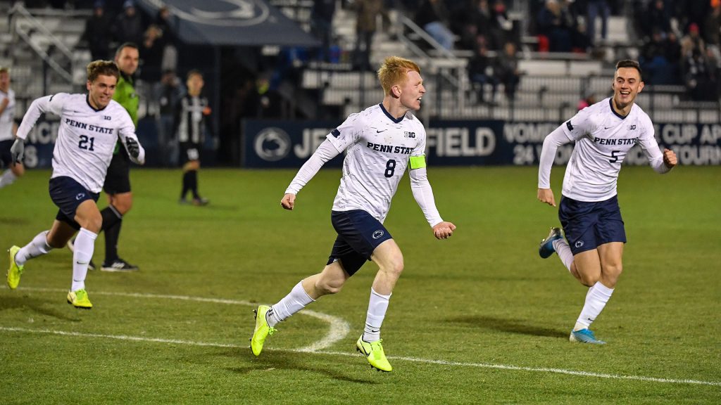 Three Penn State students playing in a soccer game