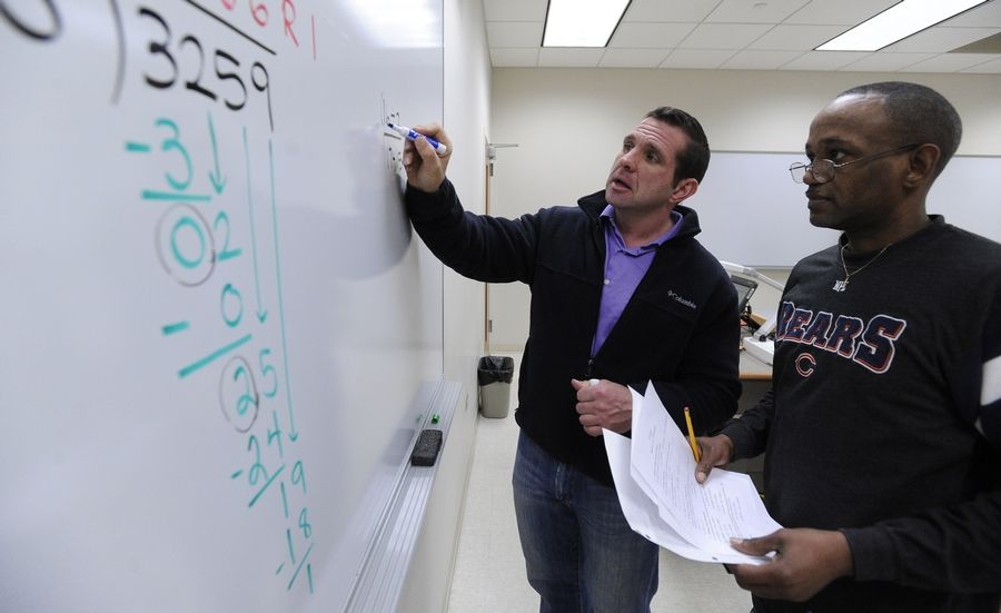 Professor working with student on the whiteboard.