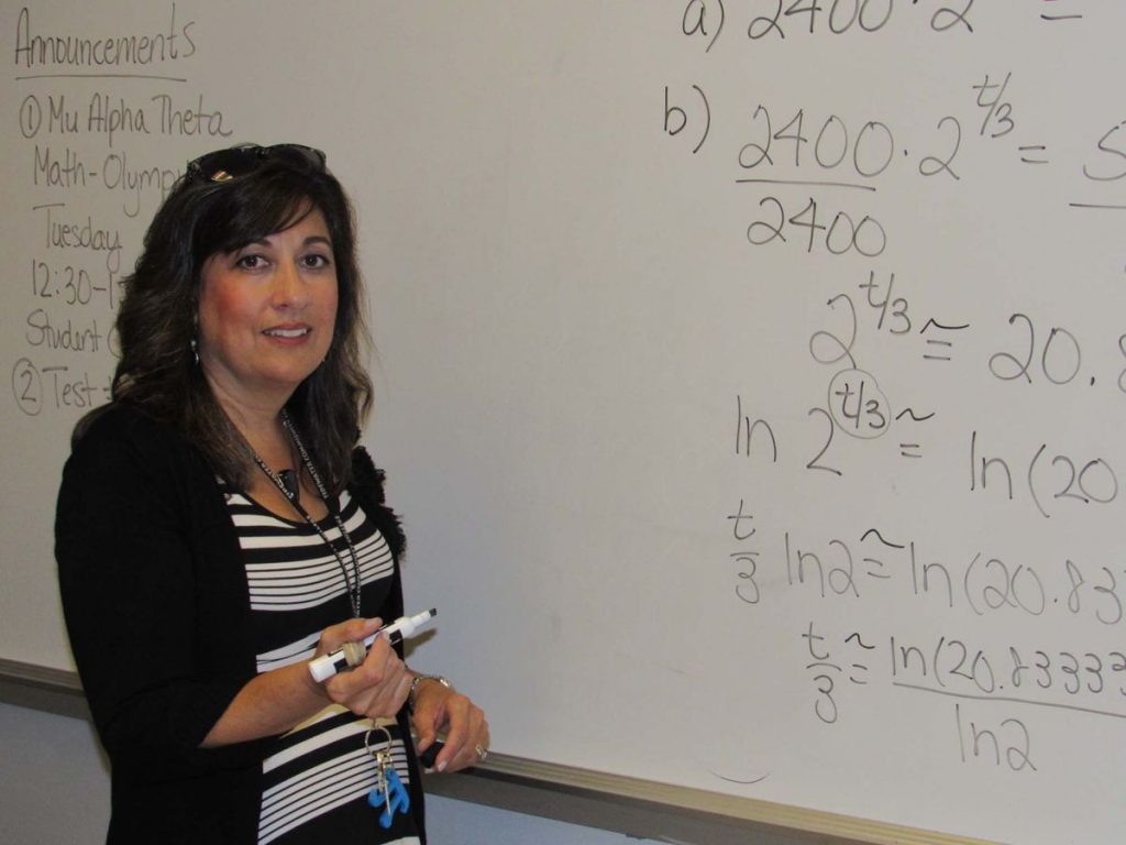 Professor teaching students on the whiteboard. 