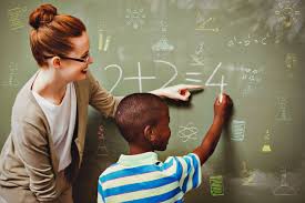 A young lady tutoring a boy in math