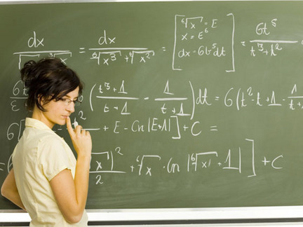 Student trying to solve equation problems on the board. 