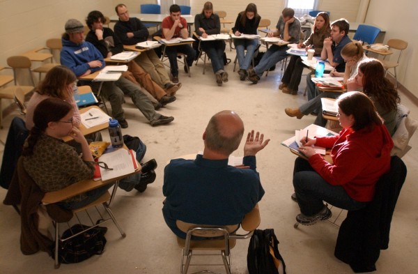 Professor sits in a group with students.