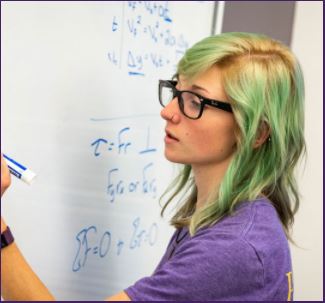 East Carolina University math student solving problem on a white board