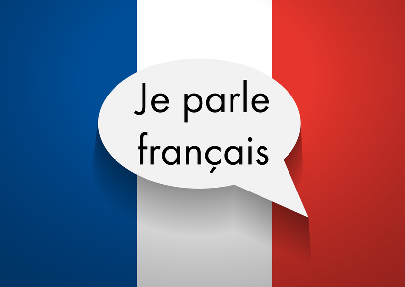 The phrase "Je parle francais" in front of a French flag