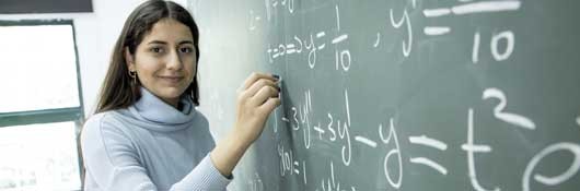 American River College math student solving math problem on a blackboard